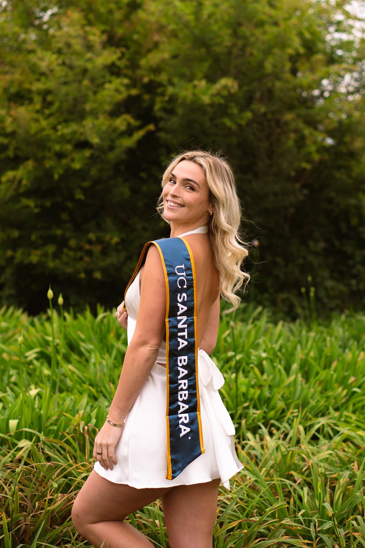 Wide shot of graduate with campus backdrop
