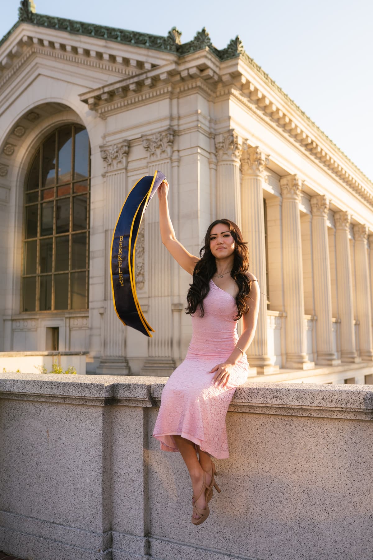 Graduate with cap raised at historic building